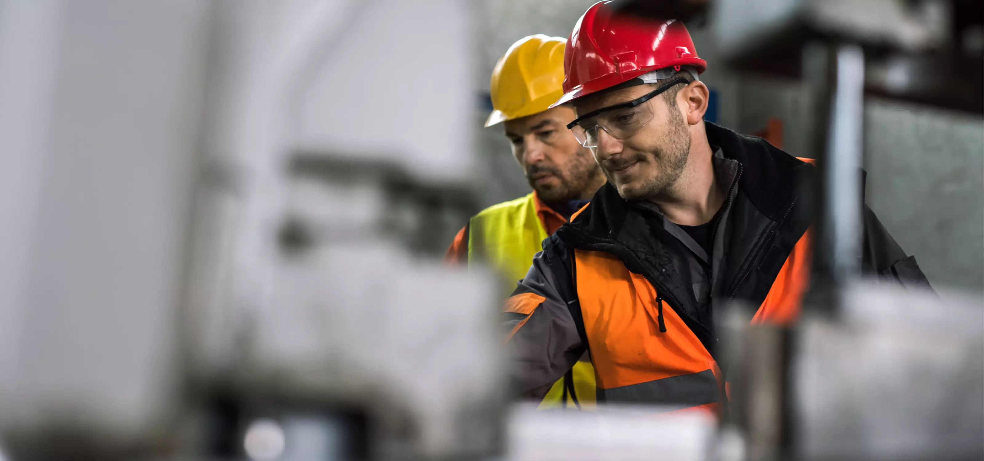 Deux hommes travaillent avec des casques de chantier