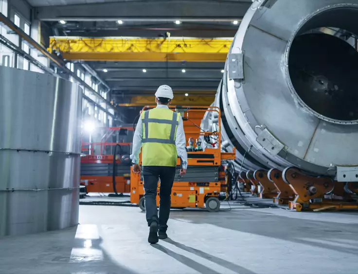 Photo d'un collaborateur technique dans une halle industrielle